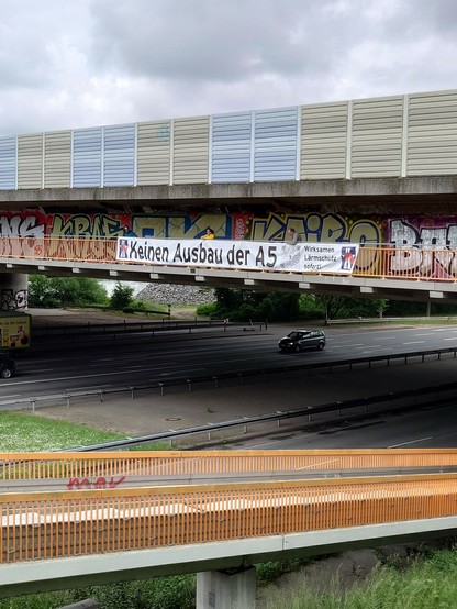 Europabrücke mit unserem großen Banner am Geländer des Radwegs unter der Autobahn: unser Logo, „Keinen Ausbau der A5“, und QR-Code mit Link zu unserer Homepage.