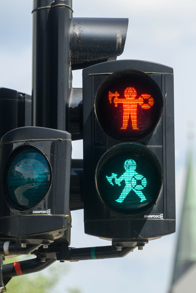 Pedestrian traffic light with both red and green on, both showing a viking (stopping and walking)