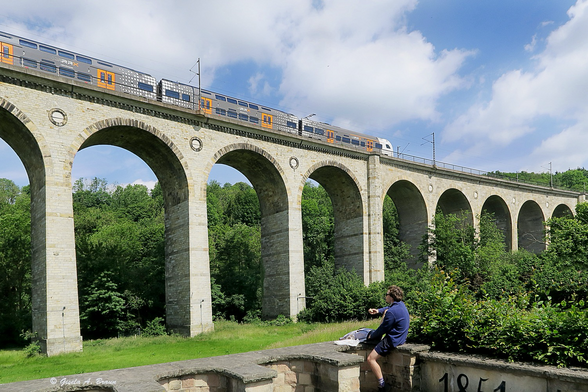 Viadukt Altenbeken von der Straße aufgenommen mit DB Reisezug bei sonnigenm Wetter morgens. 