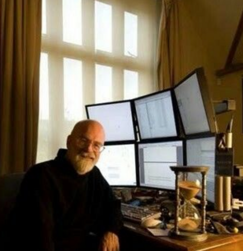 Terry Pratchett am Schreibtisch mit 2x3 Monitoren