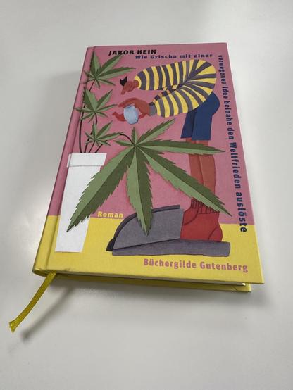 Die Hardcover-Ausgabe des Romans
JAKOB HEIN „Wie Grischa mit einer verwegenen Idee beinahe den Weltfrieden auslöste“ der Büchergilde Gutenberg liegt auf einer weißen Tischplatte. 