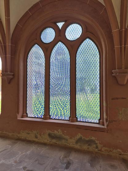 Pietà-Fenster in gotischen Fenster im Kloster Eberbach, von Thomas Bayrle. Das Motiv ist aus lauter blauen Handys zusammengesetzt. 